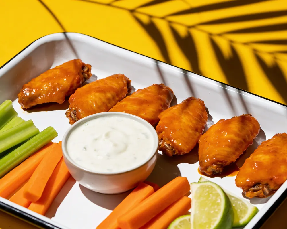 Buffalo wings with ranch on a yellow table